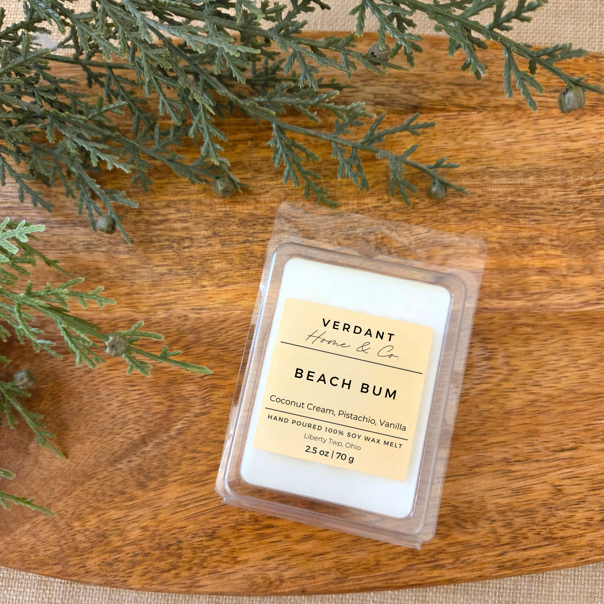 Packaged wax melt labeled 'Beach Bum' by Verdant Home Co on a wooden surface with greenery.