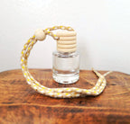 Small vial of Verdant Home & Co hanging diffuser on a wooden surface with a white background.