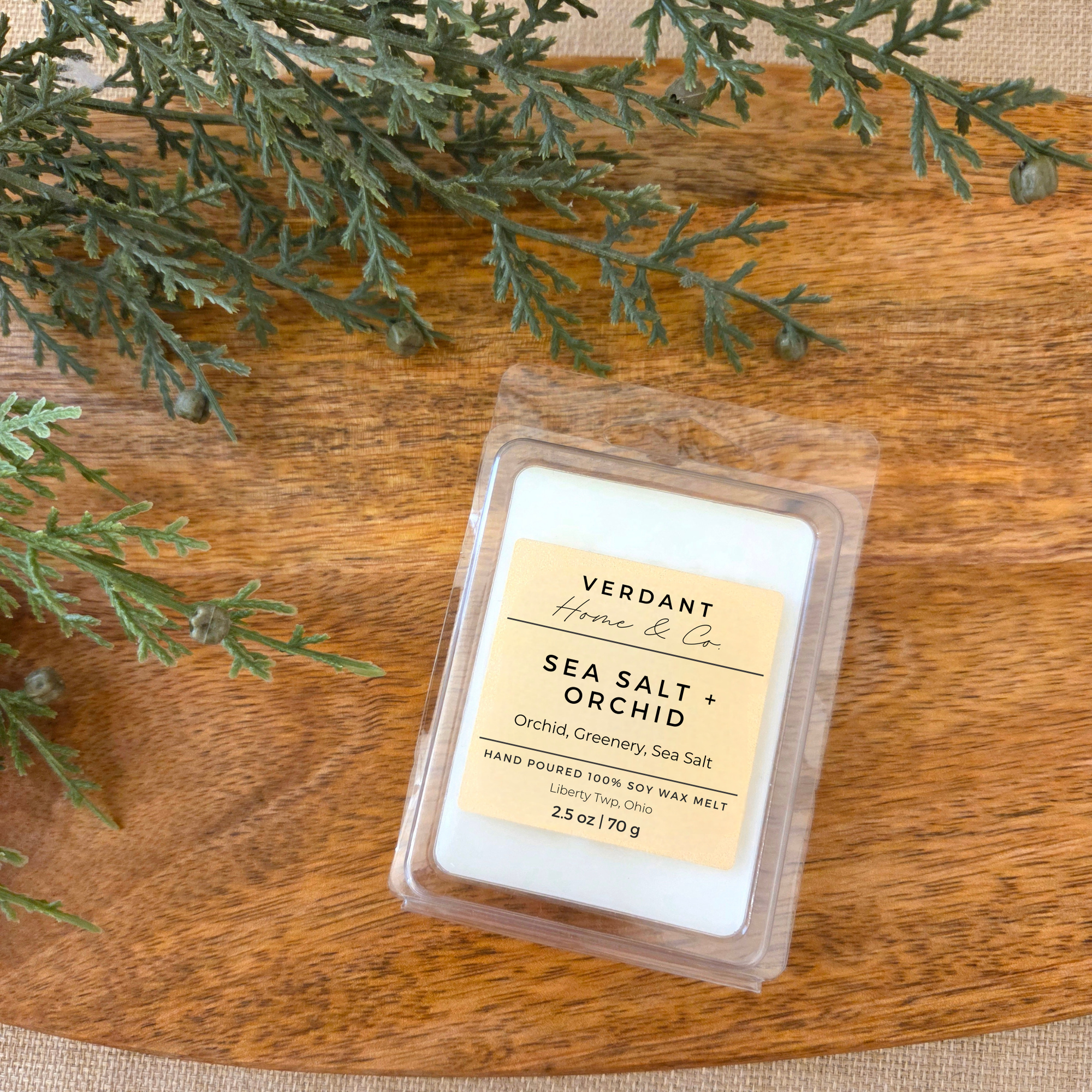 Wax melt Sea Salt + Orchid with 'Verdant Home & Co' label on a wooden surface with greenery