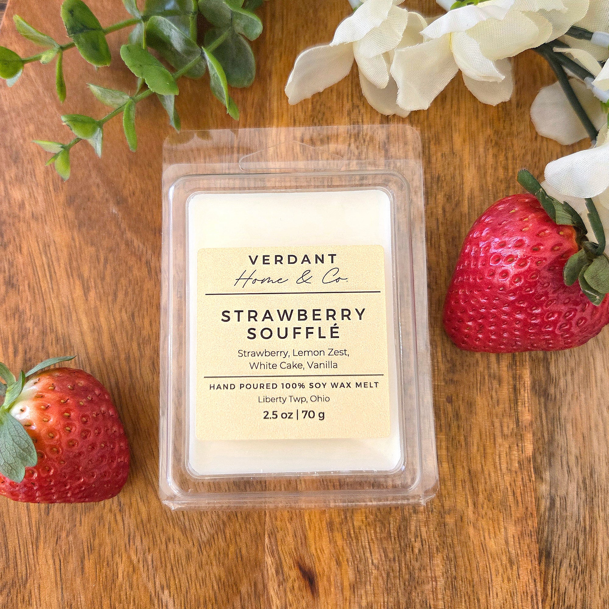 Verdant Home & Co Strawberry Souffle wax melt with strawberries and flowers on a wooden surface