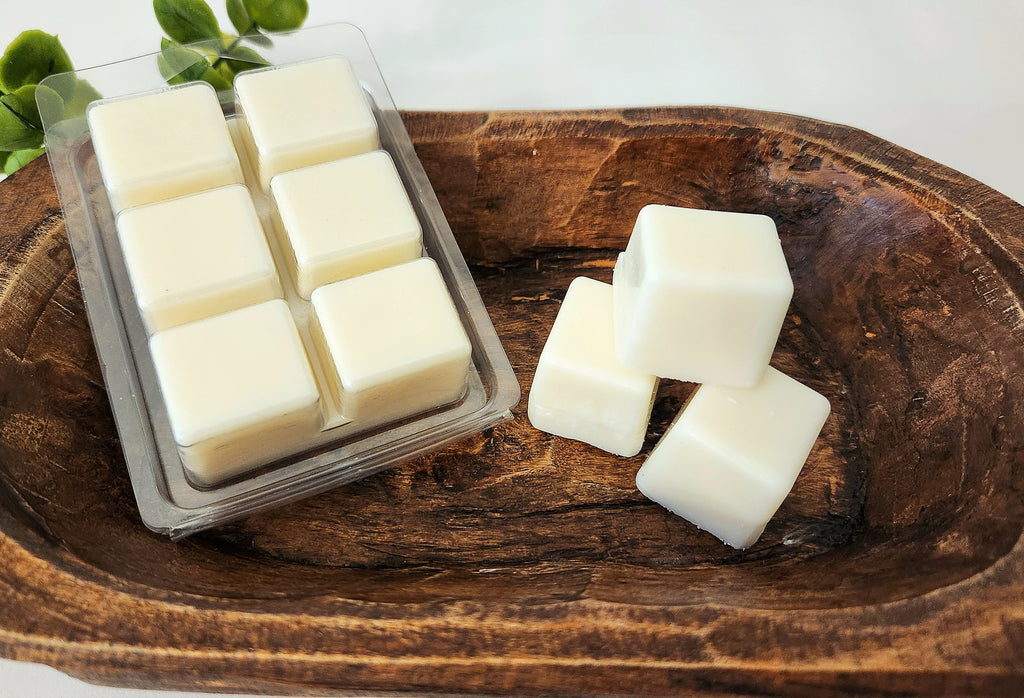 White wax melts in a clear mold on a wooden surface, no label